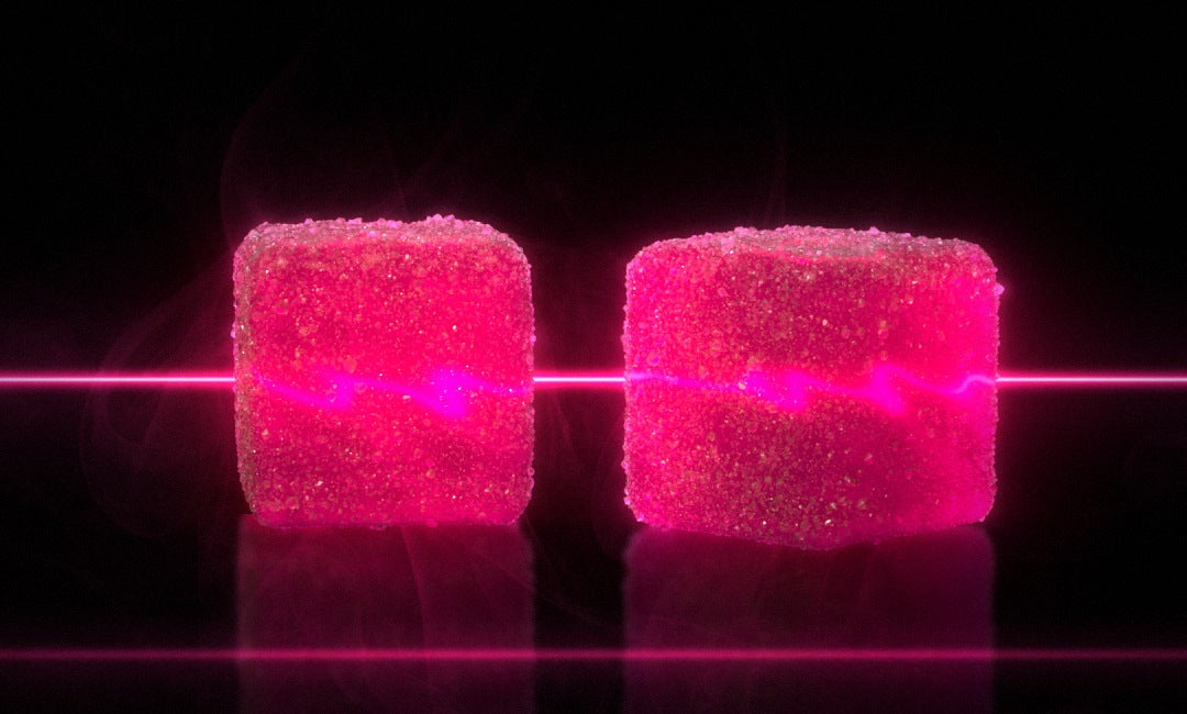 Two PUMP+ Sour Watermelon Blitz gummies on a pink light bar, one serve